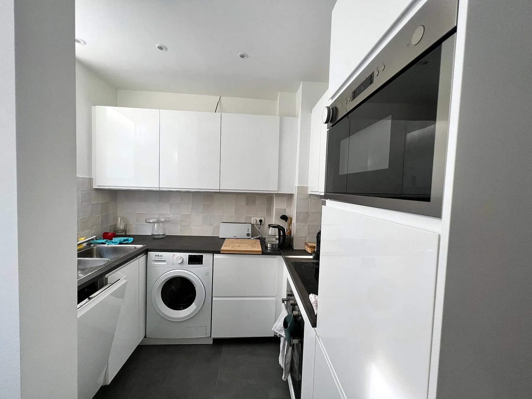 White kitchen with built-in oven, washer and dishwasher