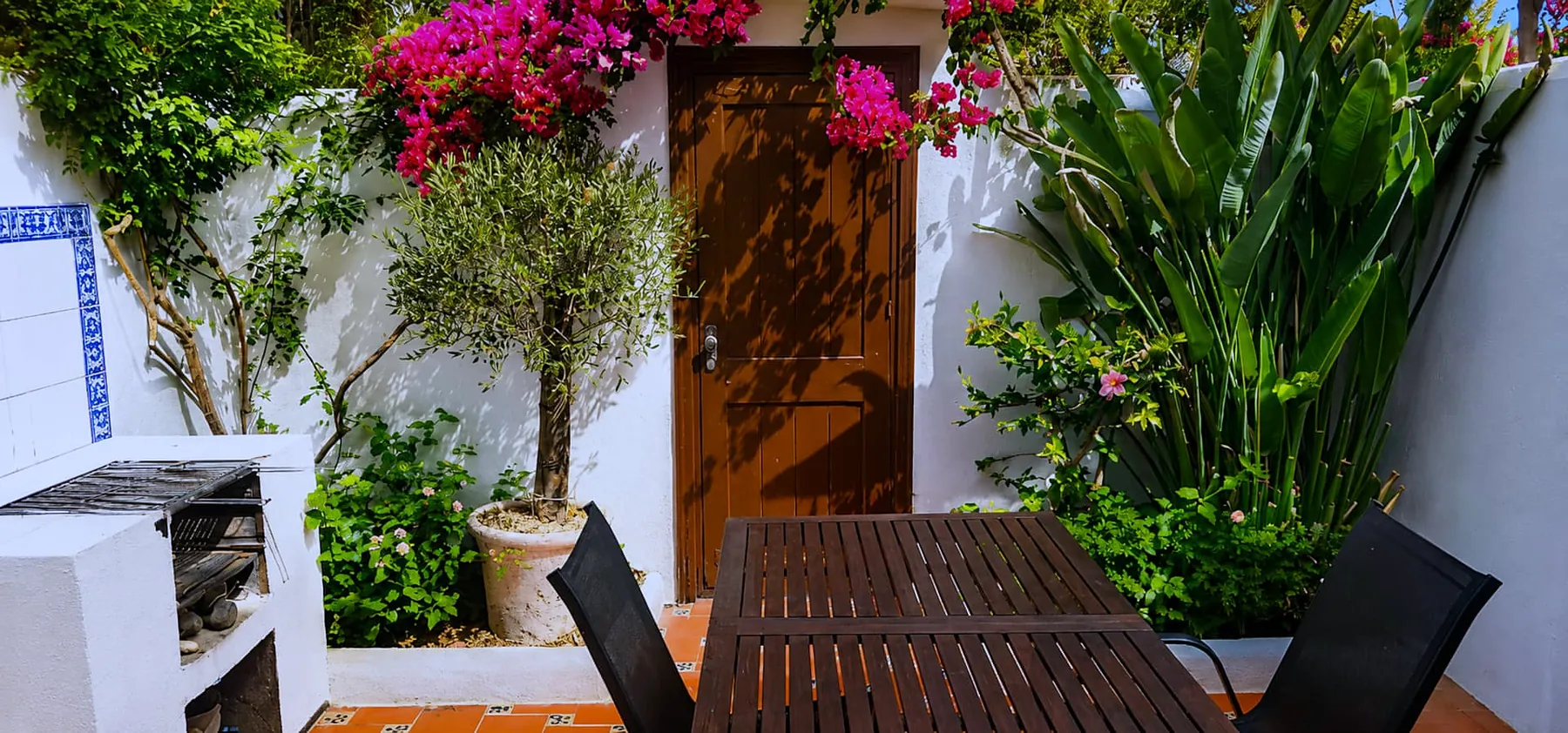 Private courtyard with bougainvillea, olive tree and outdoor dining table