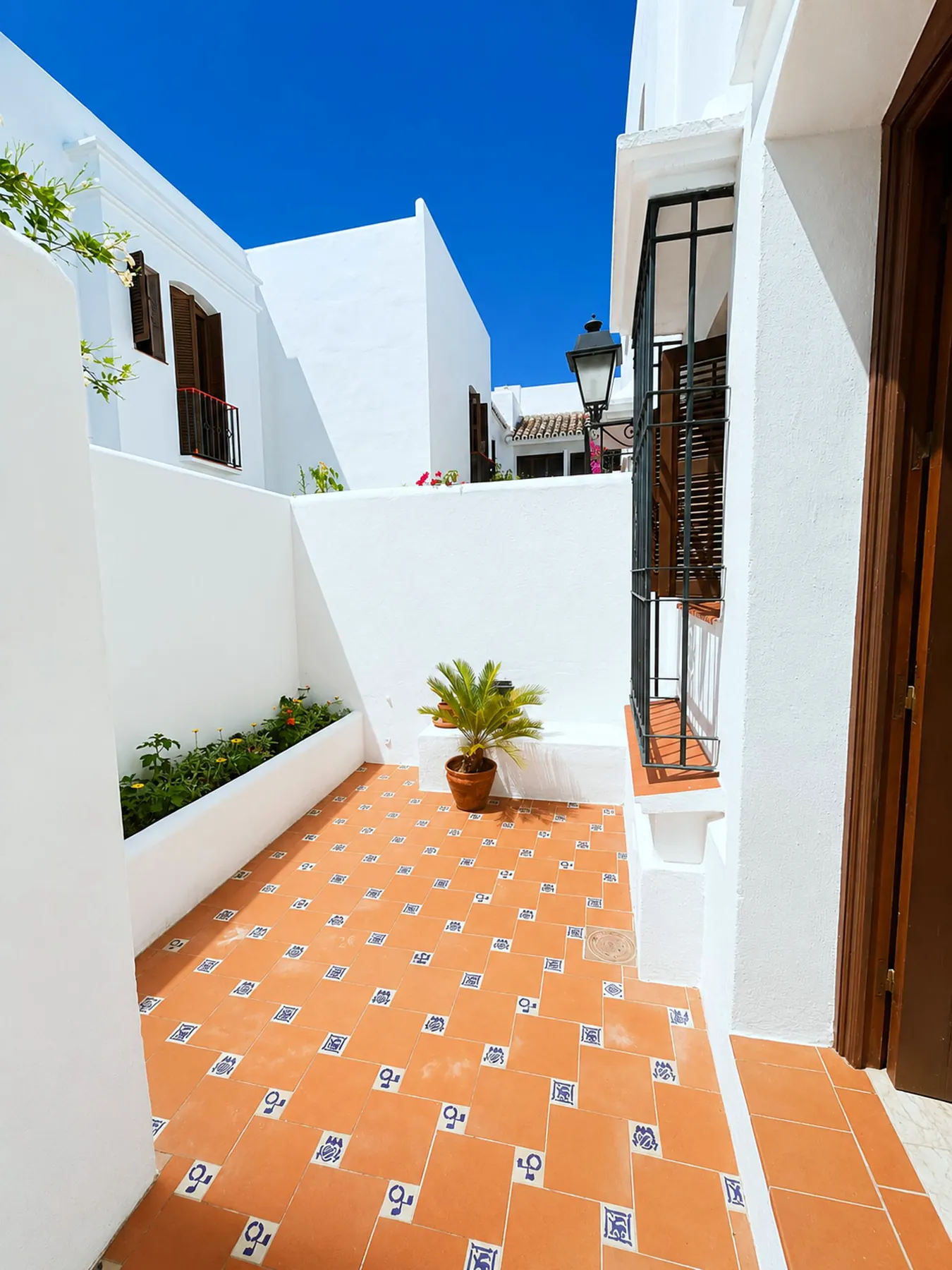Sunny upper terrace with tiled floor and white walls